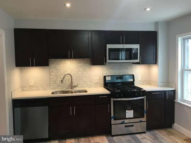 a kitchen with a sink and steel appliances