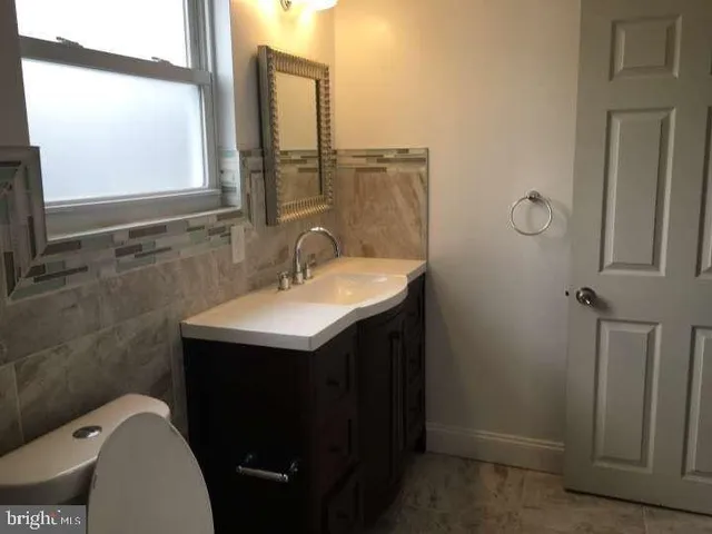 a bathroom with a sink toilet and mirror