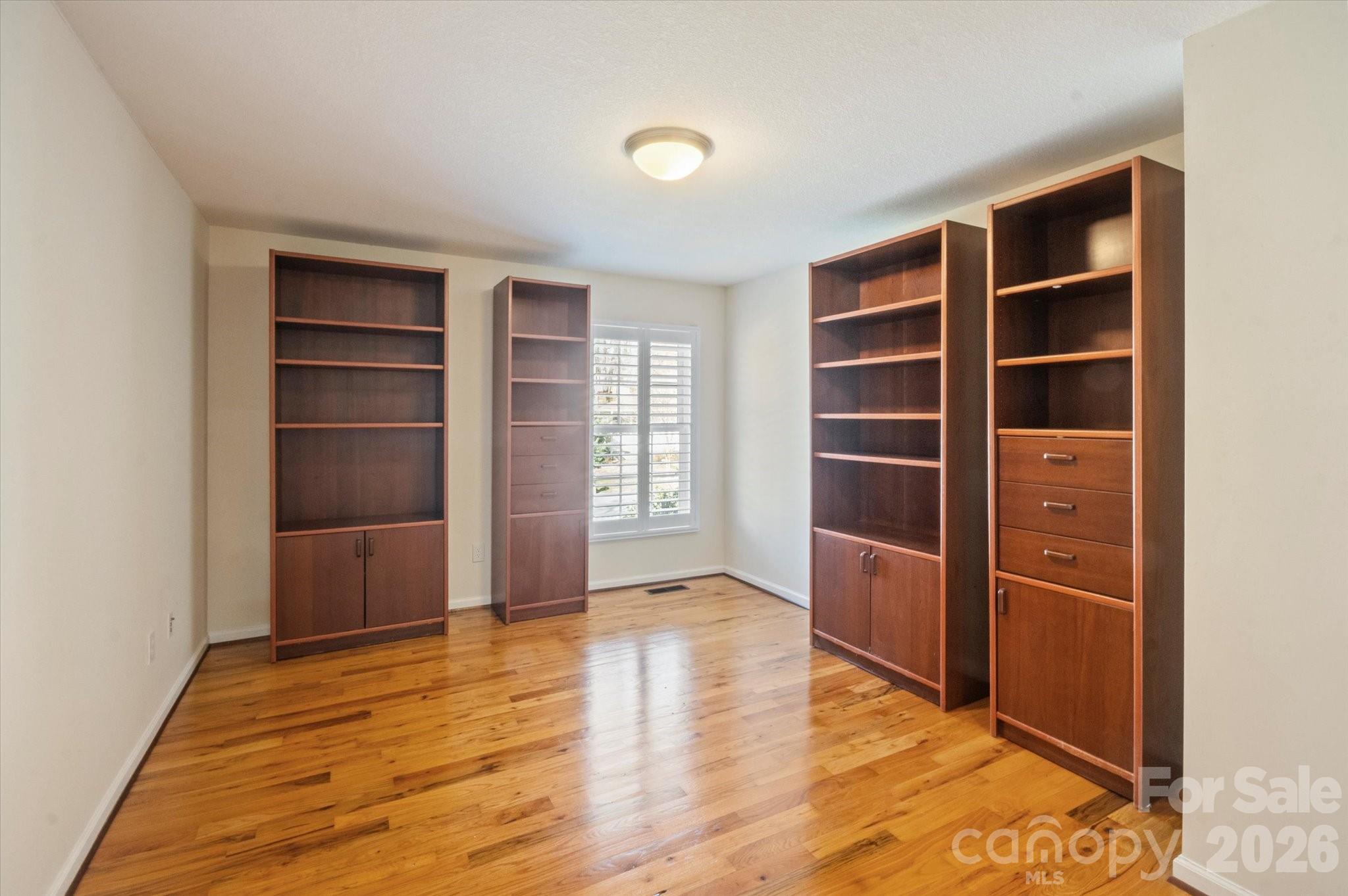 207 Allen Paul Road Hendersonville, NC 28791 - Photo 11 of 28 a view of an empty room with a closet and wooden shelves