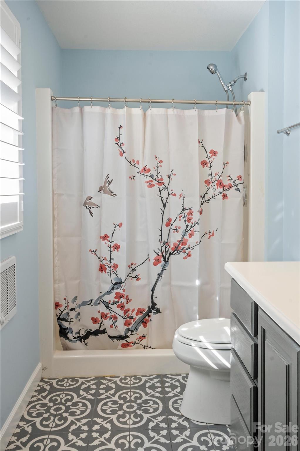 207 Allen Paul Road Hendersonville, NC 28791 - Photo 16 of 28 a white toilet sitting next to a shower curtain