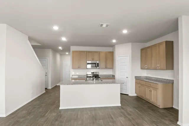 a kitchen with appliances a sink and cabinets