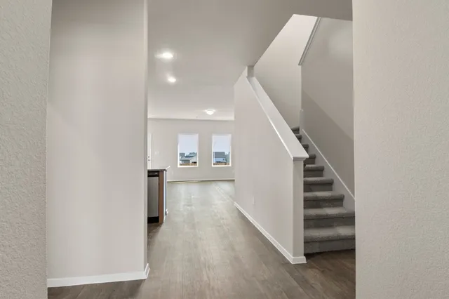 a view of a hallway with wooden floor and entryway
