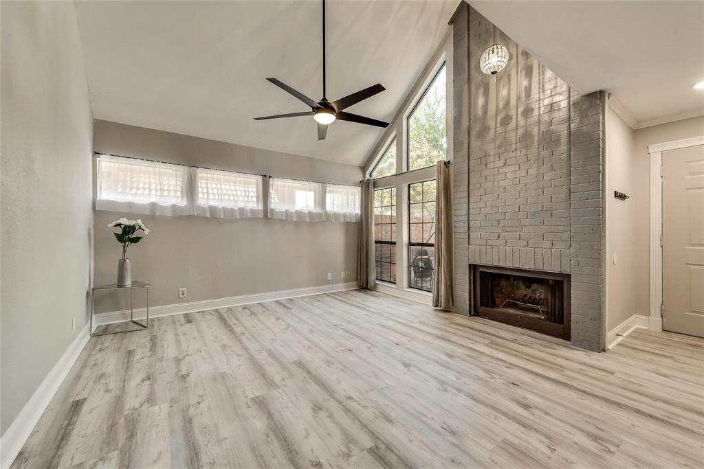 18240 Midway Road, Unit 302 Dallas, TX 75287 - Photo 2 of 33 a view of an empty room with wooden floor fireplace and a window