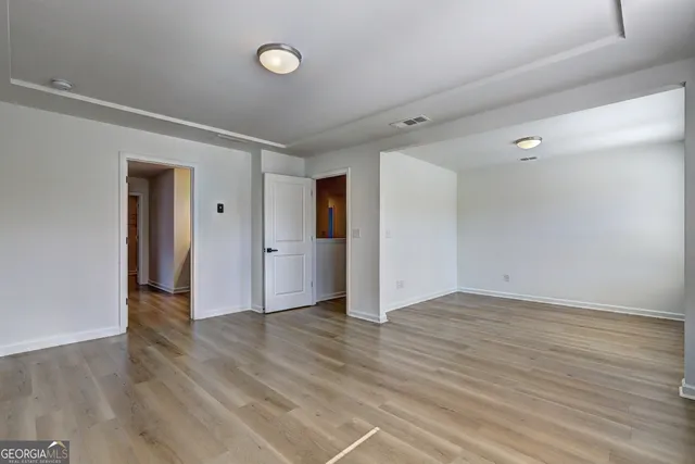 a view of an empty room with wooden floor