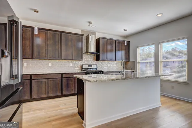 a kitchen with stainless steel appliances granite countertop a stove a sink and a microwave