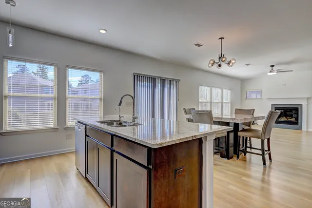 a view of kitchen island wooden floor dining table and chairs
