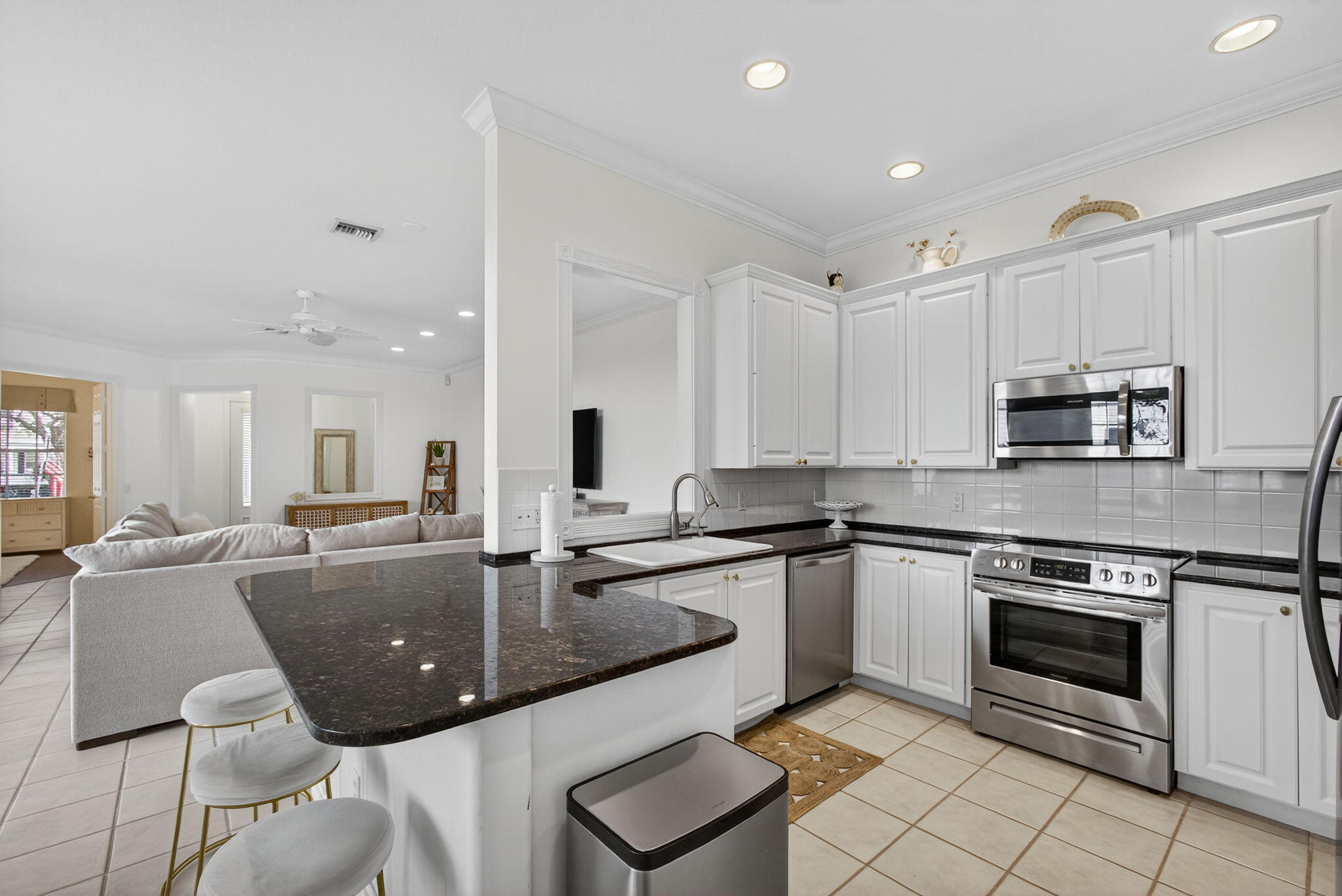 172 Queensland Lane Jupiter, FL 33458 - Photo 13 of 25 a kitchen with stainless steel appliances granite countertop a stove top oven a sink dishwasher and white cabinets with wooden floor