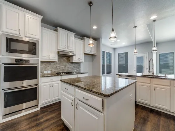 a kitchen with stainless steel appliances granite countertop a sink stove and microwave