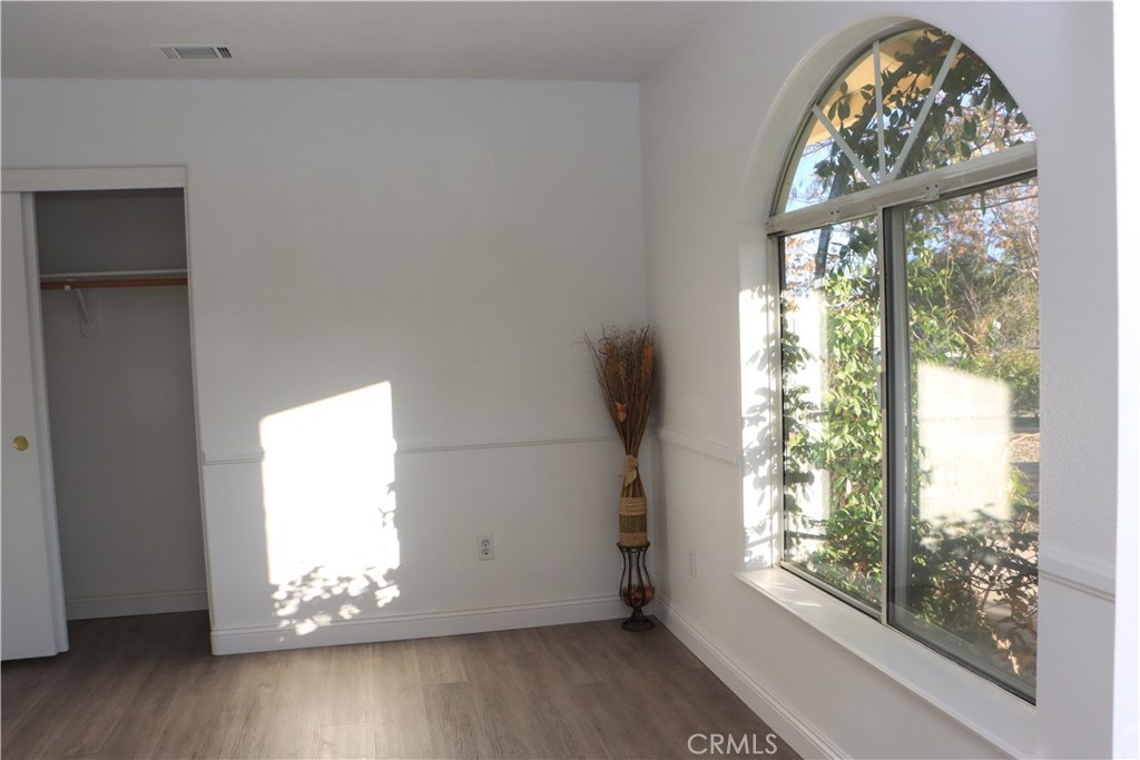15742 Muscatel Street Hesperia, CA 92345 - Photo 12 of 24 a view of an empty room with wooden floor and a window