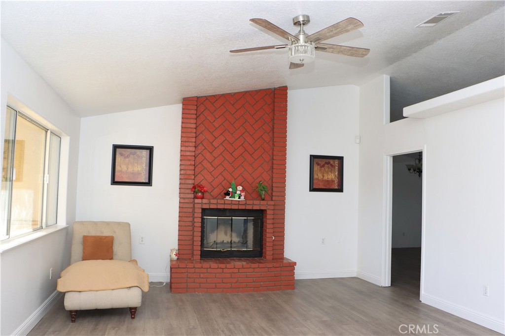 15742 Muscatel Street Hesperia, CA 92345 - Photo 2 of 24 a living room with furniture and a fireplace