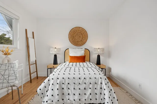 a bedroom with a bed mirror and window