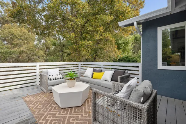 a view of a patio with a dining table and chairs with wooden floor