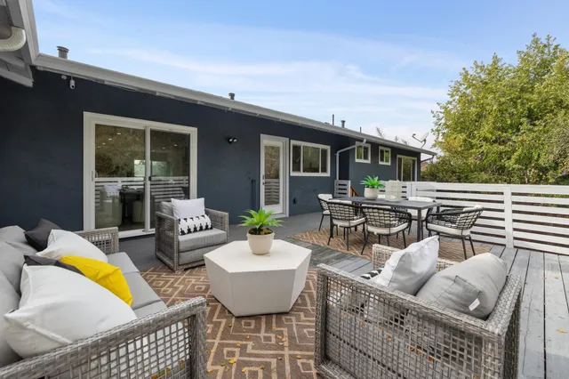 an outdoor sitting area with furniture and wooden floor