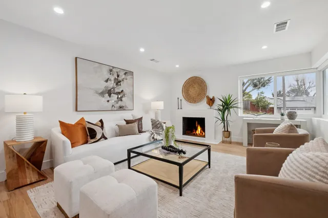 a living room with furniture a fireplace and a large window