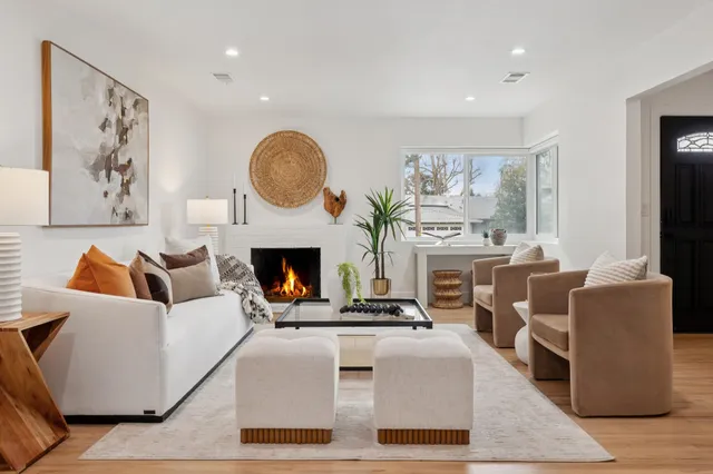 a living room with furniture a large window and a fireplace