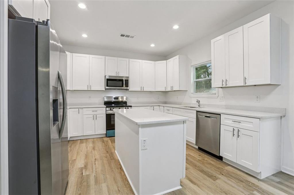 4405 Belcamp Road Fairburn, GA 30213 - Photo 11 of 60 a kitchen with white cabinets and stainless steel appliances