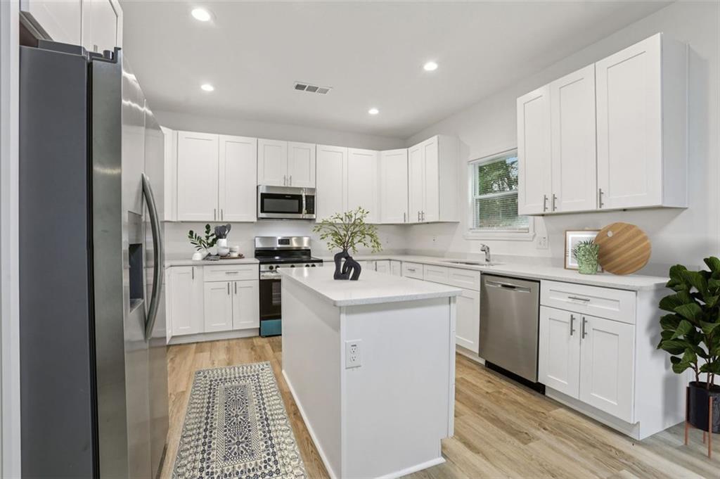 4405 Belcamp Road Fairburn, GA 30213 - Photo 12 of 60 a kitchen with white cabinets and stainless steel appliances