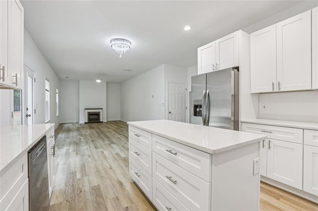 4405 Belcamp Road Fairburn, GA 30213 - Photo 14 of 60 a large white kitchen with a refrigerator a sink and cabinets