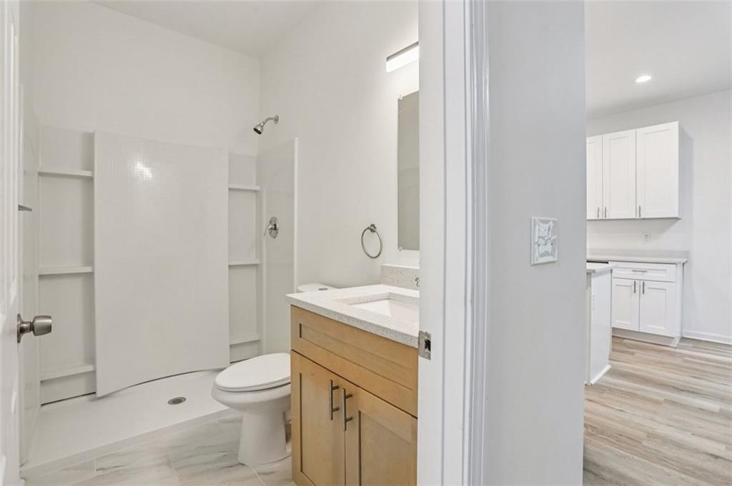 4405 Belcamp Road Fairburn, GA 30213 - Photo 17 of 60 a bathroom with a granite countertop toilet a sink and a mirror