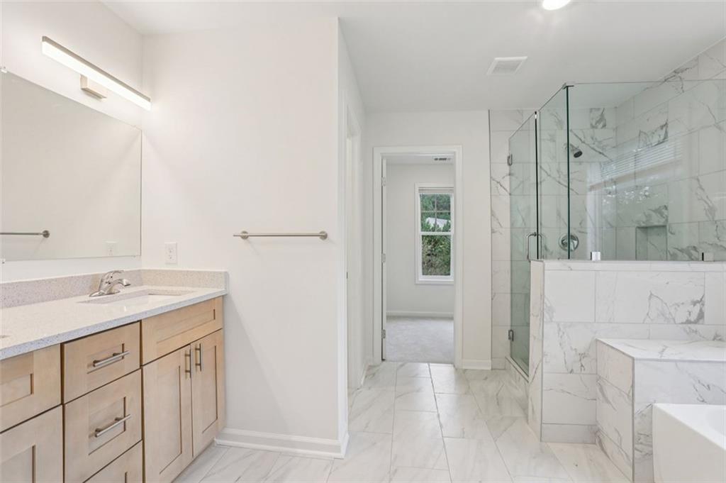 4405 Belcamp Road Fairburn, GA 30213 - Photo 44 of 60 a spacious bathroom with a granite countertop sink a mirror a shower and a bathtub