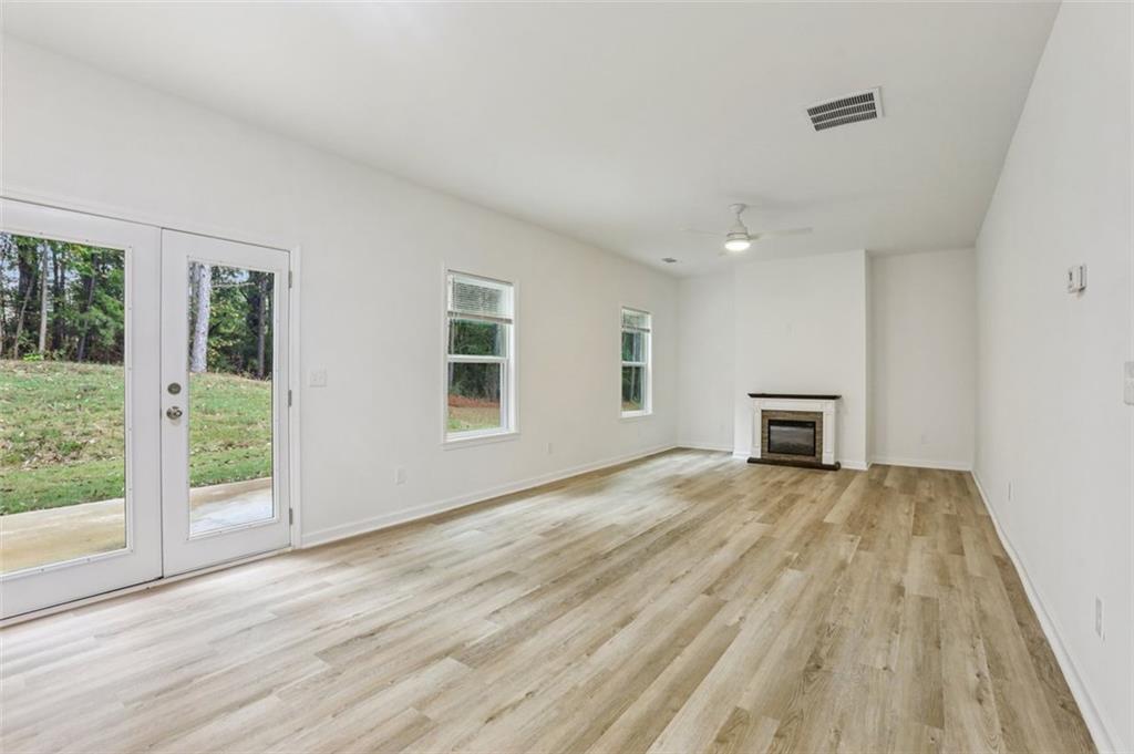 4405 Belcamp Road Fairburn, GA 30213 - Photo 6 of 60 a view of an empty room with wooden floor and a window