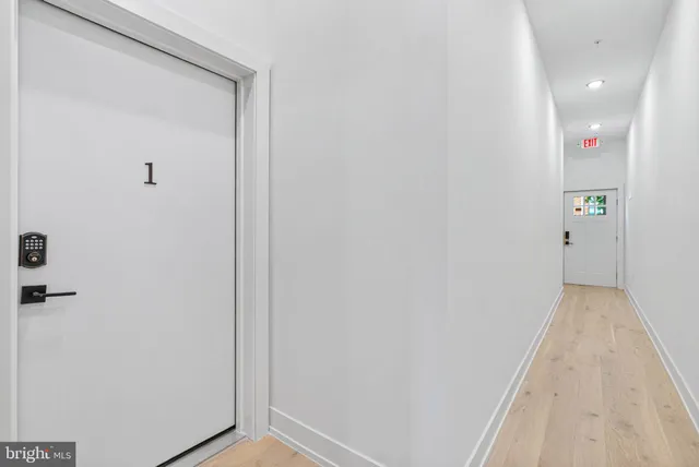 a view of a hallway with wooden floor