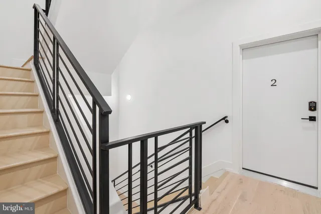 a view of staircase with railing and white walls