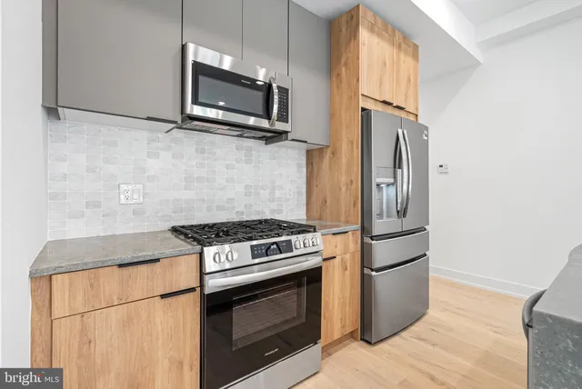 a kitchen with stainless steel appliances granite countertop a stove microwave and refrigerator