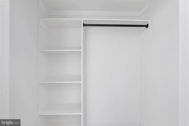 a view of walk in closet with empty racks
