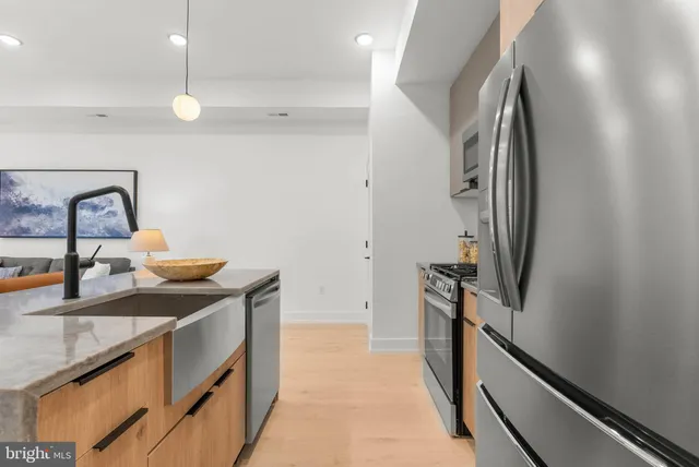 a kitchen with stainless steel appliances granite countertop a sink and refrigerator