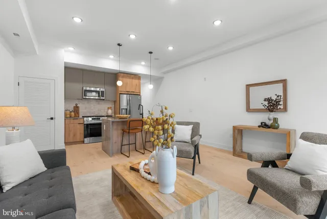 a living room with furniture and a view of kitchen