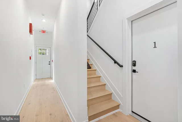 a view of a hallway with wooden floor and entryway