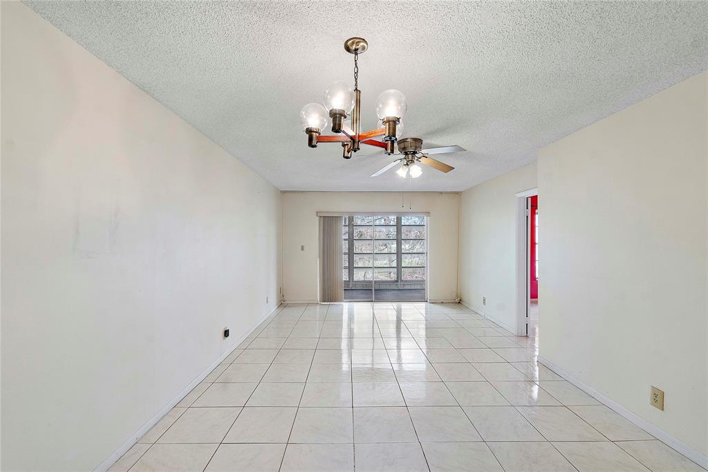 8205 Northwest 61st Street, Unit B305 Tamarac, FL 33321 - Photo 13 of 50 a view of a livingroom with a chandelier fan and windows