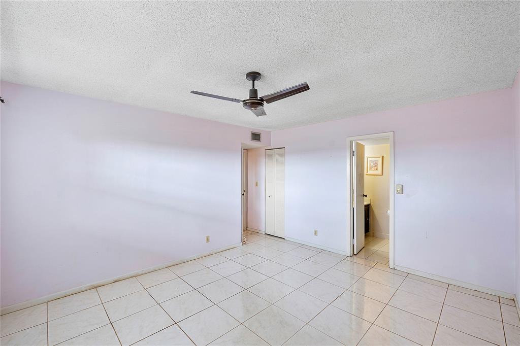 8205 Northwest 61st Street, Unit B305 Tamarac, FL 33321 - Photo 21 of 50 a view of a livingroom with a ceiling fan & cabinets