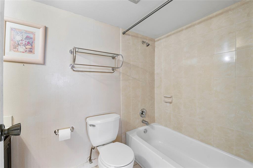 8205 Northwest 61st Street, Unit B305 Tamarac, FL 33321 - Photo 25 of 50 a bathroom with a toilet and a shower curtain