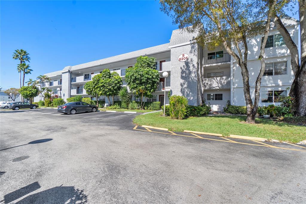 8205 Northwest 61st Street, Unit B305 Tamarac, FL 33321 - Photo 33 of 50 a view of road with plants and large trees