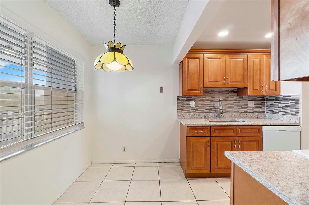 8205 Northwest 61st Street, Unit B305 Tamarac, FL 33321 - Photo 9 of 50 a kitchen with a sink a counter top space cabinets and a window