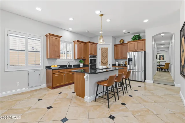 a kitchen with stainless steel appliances granite countertop a stove a sink and a refrigerator