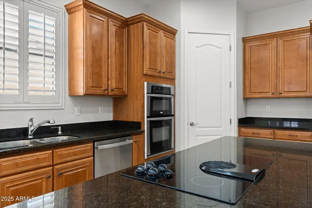 a kitchen with stainless steel appliances kitchen island granite countertop a sink and cabinets