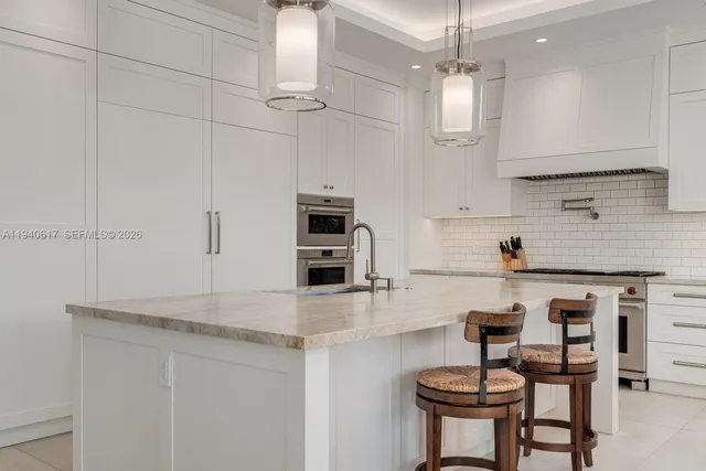 a kitchen with kitchen island a sink a counter top space appliances and a center island