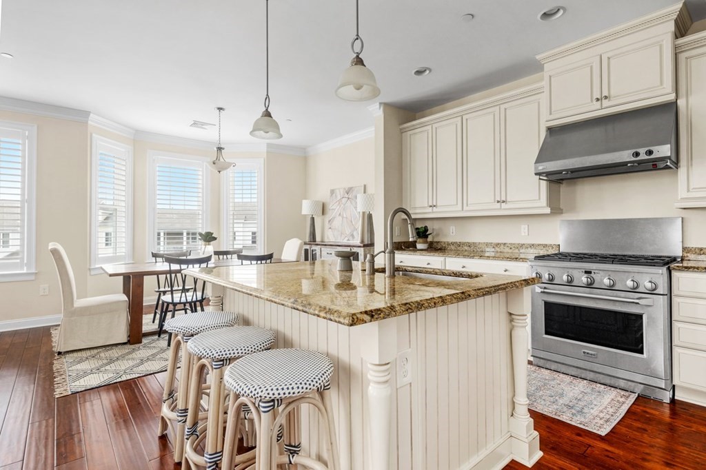 113 Halsted, Unit 113 Hingham, MA 02043 - Photo 11 of 41 a kitchen with granite countertop a sink a stove a oven a dining table and chairs