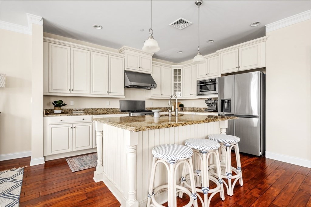 113 Halsted, Unit 113 Hingham, MA 02043 - Photo 9 of 41 a kitchen with white cabinets and stainless steel appliances