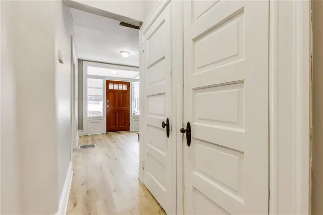a view of a hallway with wooden floor and closet