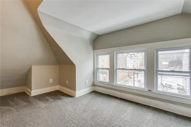 an empty room with mirror in hallway