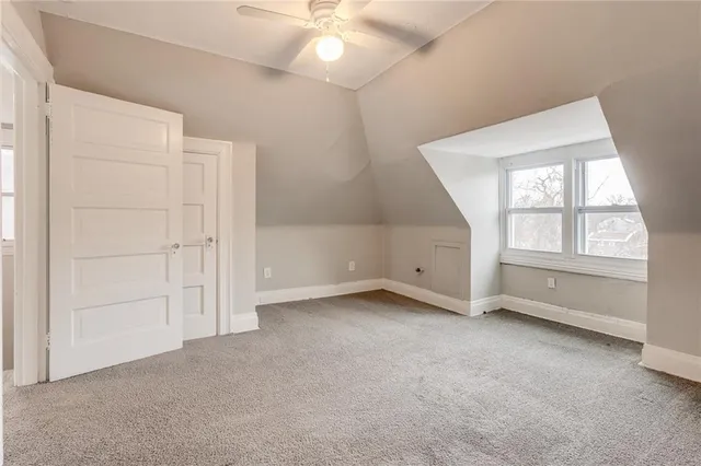 an empty room with a ceiling fan and window