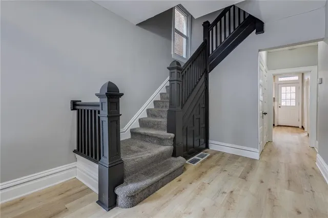 a view of entryway and hall with wooden floor