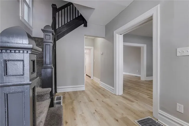 a view of hallway with stairs and wooden floor
