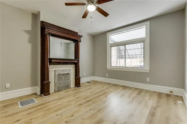 a view of an empty room with a fireplace and a window
