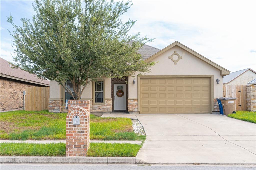 a front view of a house with a yard and garage