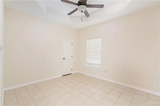 an empty room with a ceiling fan and window